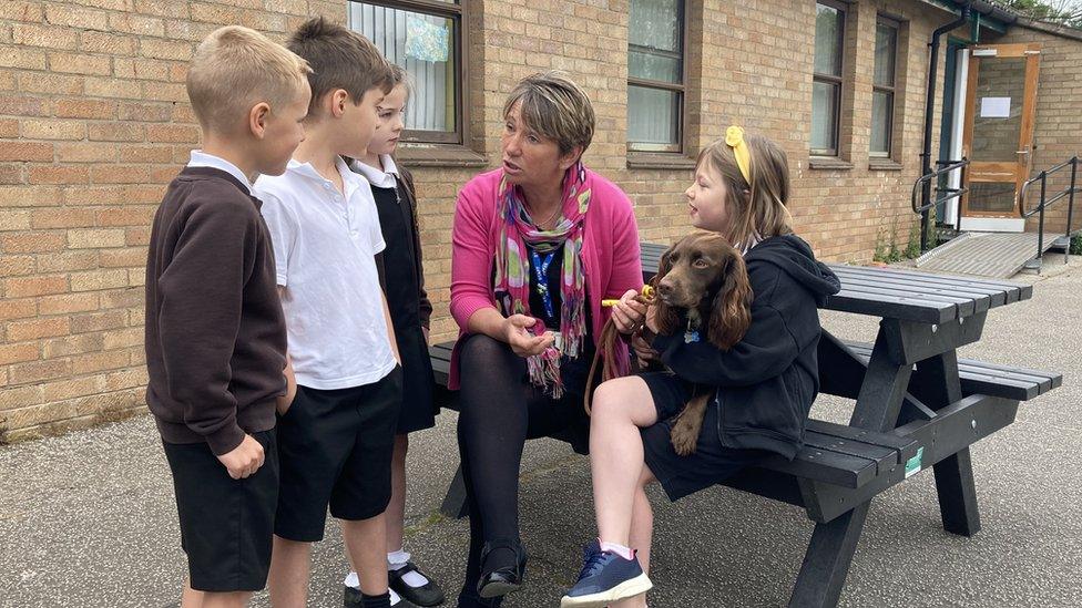 Therapy dog Darcy, with head teacher Rachel Bailey and children from Abbotts Hall Primary School