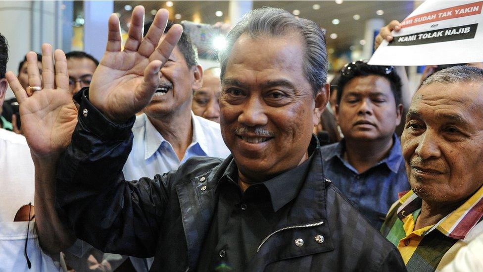 Former Malaysian Deputy Prime Minister Muhyiddin Yassin waves to photographers upon his arrival at Kuala Lumpur International Airport on 1 March