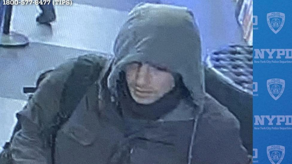 CCTV image showing man wearing hooded jacket with backpack slung over his right shoulder