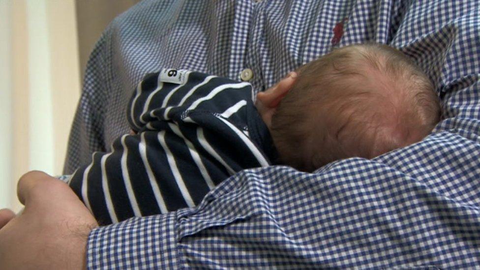 Christopher Jones holding his baby