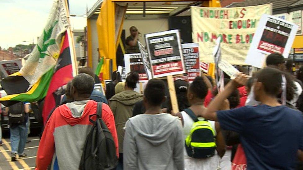 Protesters march with banners