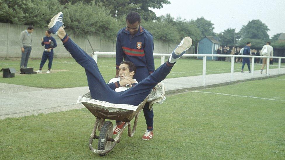 Portuguese footballer Vicente Lucas pushing team mate Jose Torres in a wheelbarrow at a training session during the 1966 World Cup in England, July 1966. (Photo by Central Press/Hulton Archive/Getty Images)