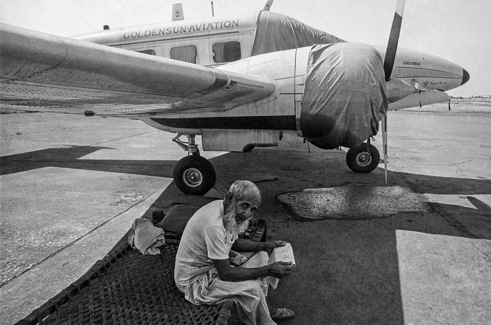 A security guard sits on charpoy at the Juhu Airport in 1982