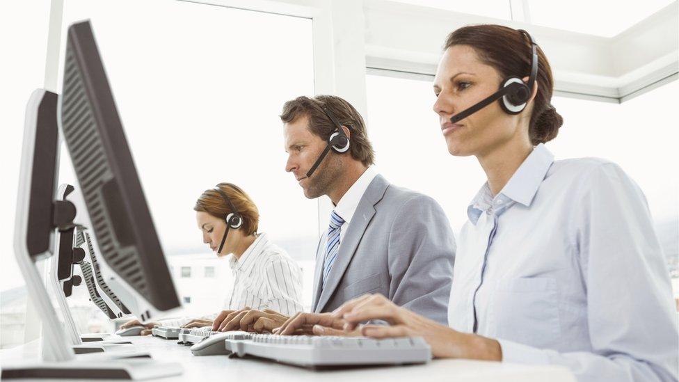 Business people with headsets at terminals