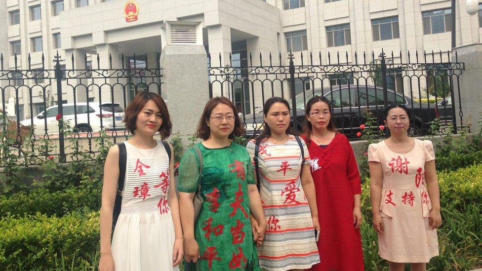 Wives protesting outside the top prosecutor's office. The characters on the dresses read (from left to right): "Quanzhang, I am waiting for you", "If you want to marry a husband, Li Heping is the one", "Geping, love you", "Zhai Yanmin" (Zhai Yanmin is one of the detained activists) and "Xie Yang, I support you"