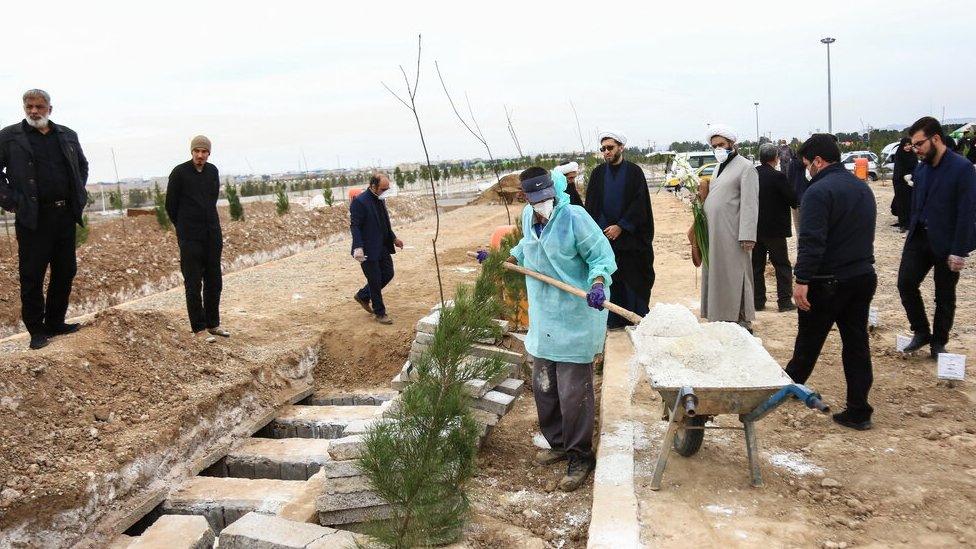 Worker pouring lime onto graves