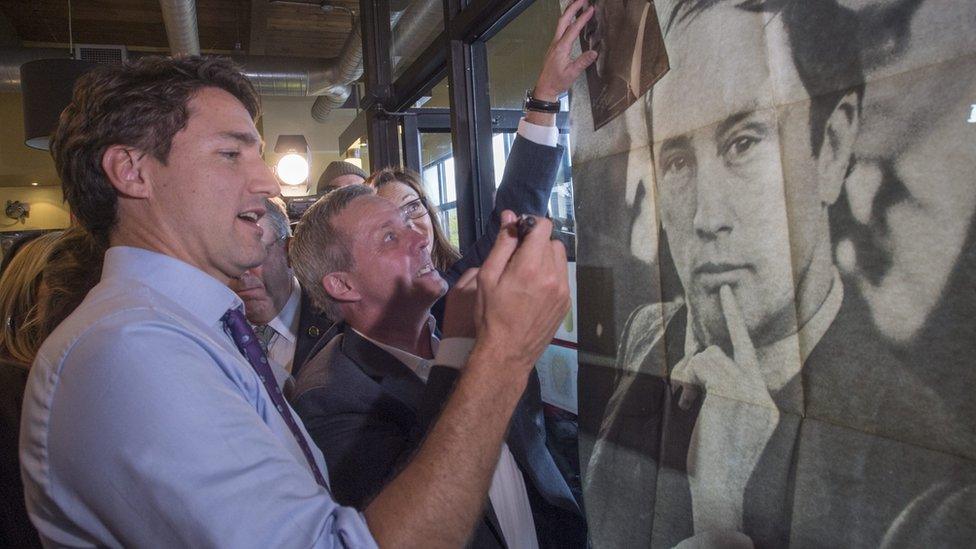 Justin Trudeau signs a photo of his father during an October campaign stop