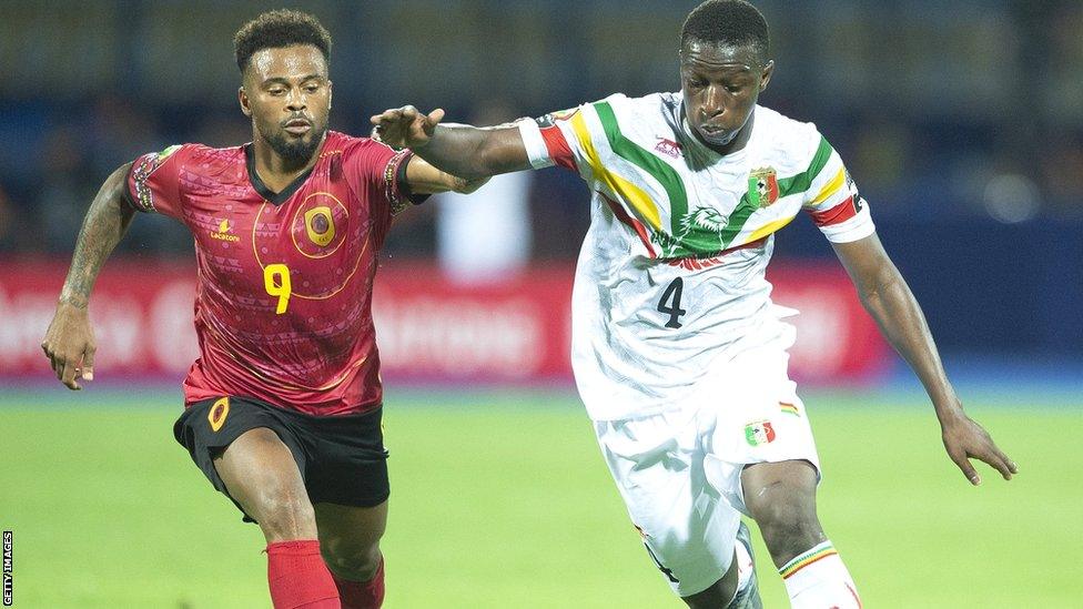 Angola striker Fredy competes with a defender for the ball