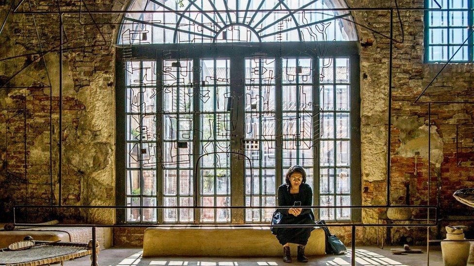 A woman sits at the exhibition of Bangladesh at the 16th Venice Biennale in Venice