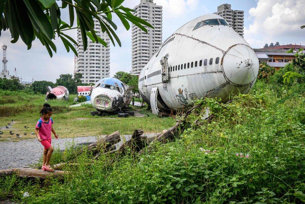 A child plays in front of abandoned aircraft in the suburbs of Bangkok on 9 October 2019. The area, known as the "airplane graveyard", has become a tourist attraction in the Thai capital.