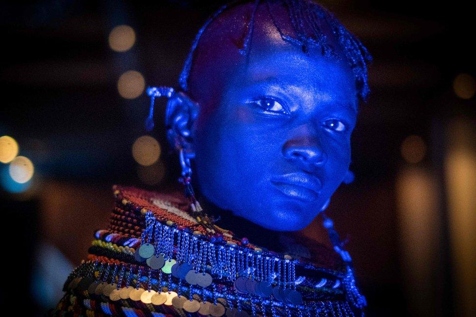 A dancer of Turkana tribe performs in blue light during the launching ceremony of the 11th Marsabit-Lake Turkana Cultural Festival in Nairobi, Kenya, on June 20, 2018.