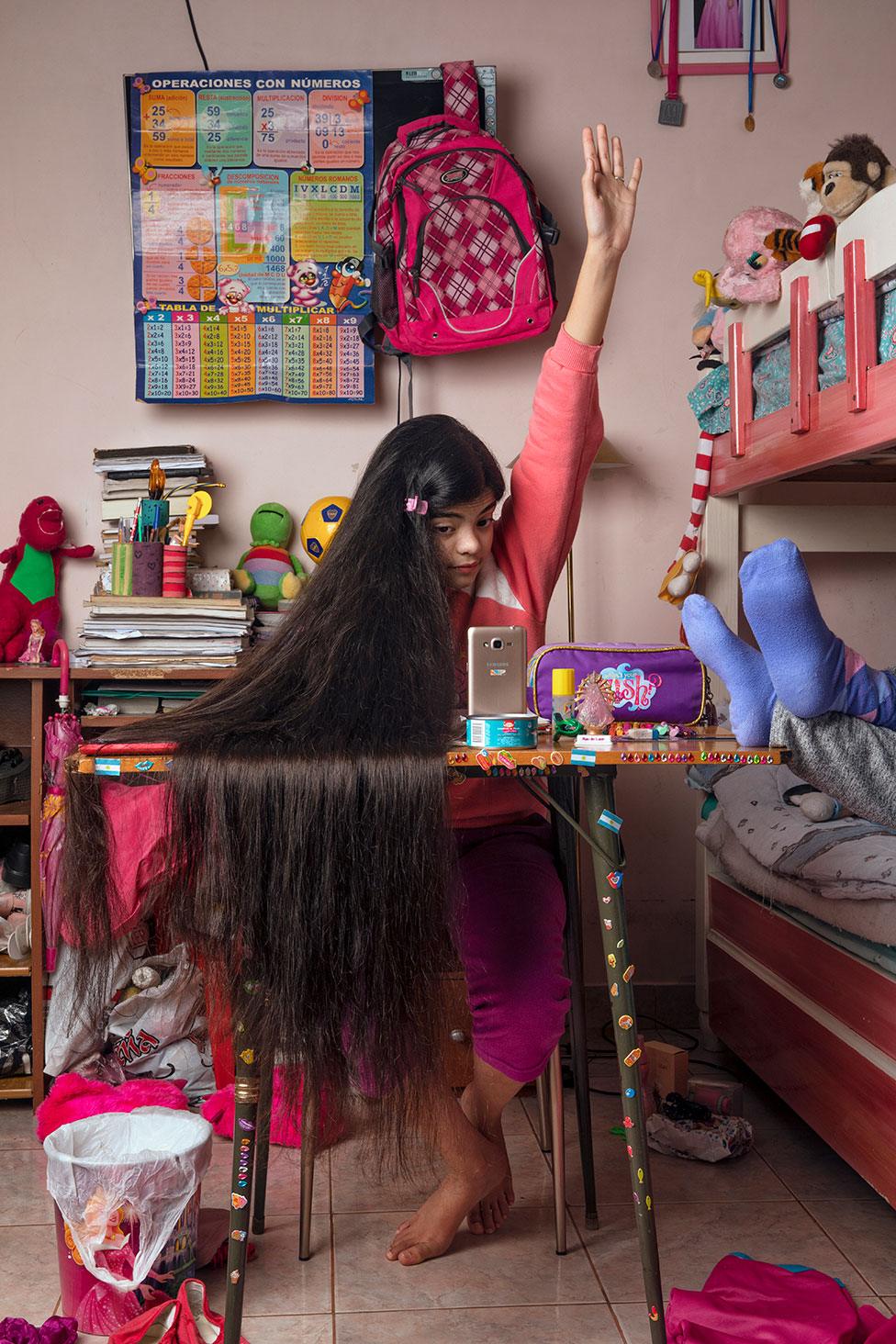 Antonella studies in her bedroom via Zoom, using her mother's mobile phone, in her room at home in Buenos Aires, Argentina, on 13 June 2021