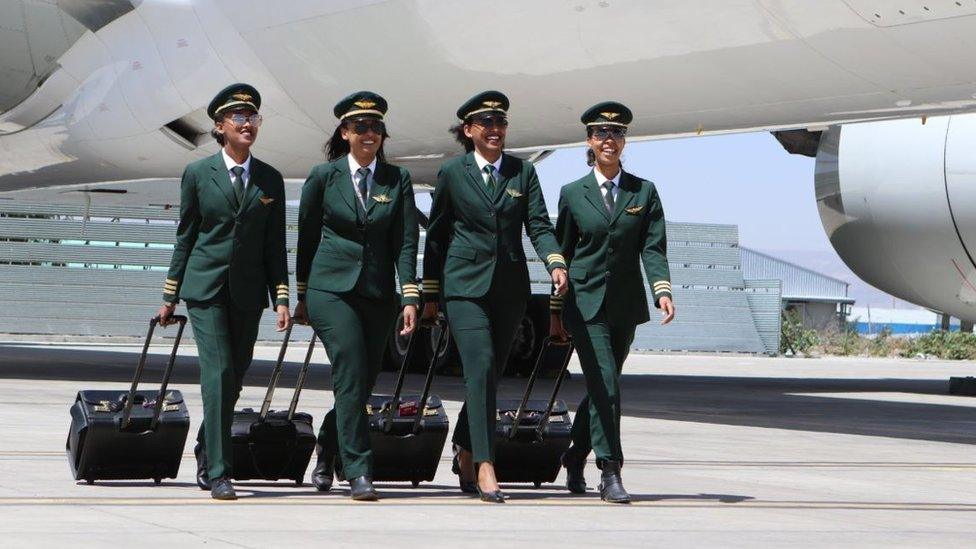 Female cabin crew on tarmac next to plane