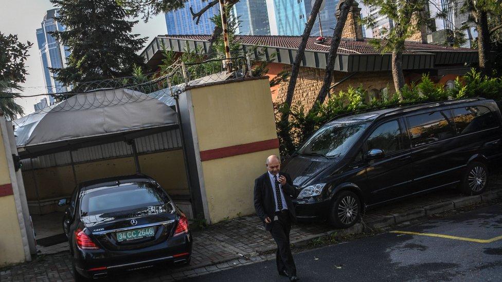 A security member of the consulate stands guard as a diplomatic vehicle arrives at the Saudi Arabian consulate in Istanbul on October 12, 2018