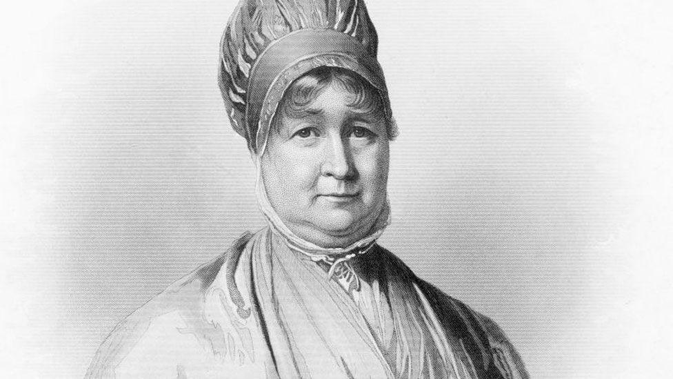 A black-and-white line portrait of Elizabeth Fry. She is wearing a turban-style hat and her hair is curling on her forehead. The high collar of her shirt comes up around her neck and her dress is crossed over her chest, with a glimpse of a lighter-coloured shirt beneath