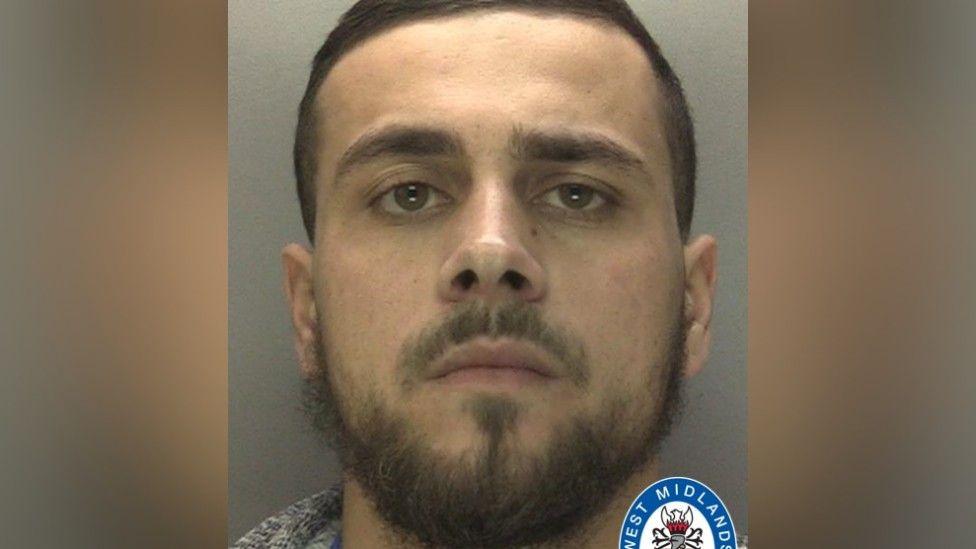Kye Lemathy seen in a police mugshot. He has a beard and short hair and is staring at the camera.