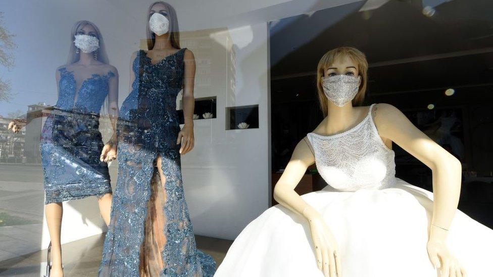 Wedding shop window with bride wearing a face mask