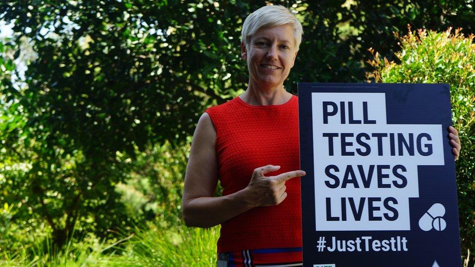 Cate Faehrmann holds a sign saying: "Pill testing saves lives".