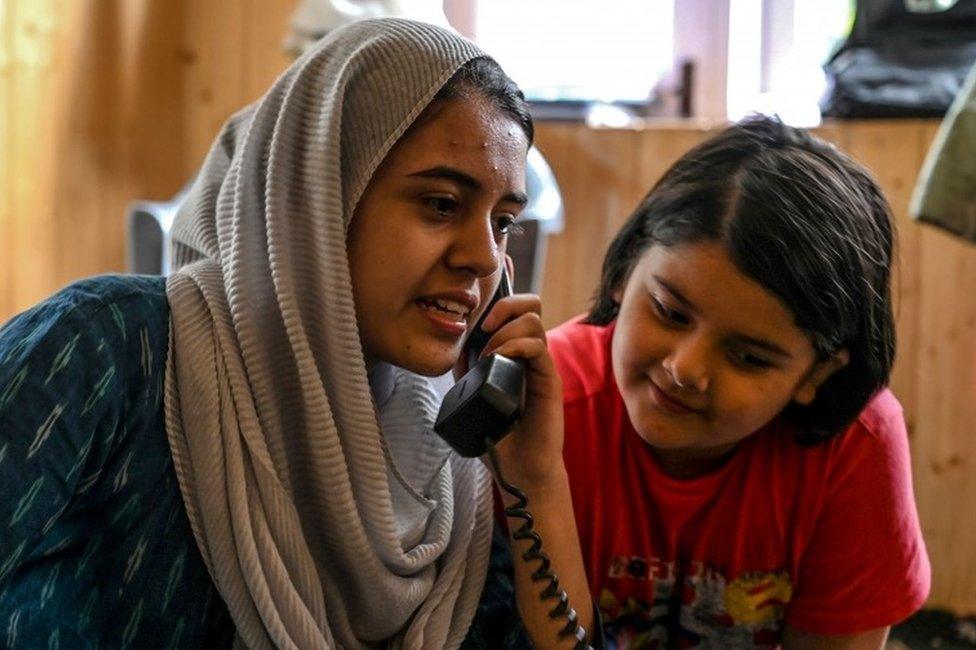 In this photo taken on August 17, 2019, Kashmiri Muslims talk to relatives on a landline phone in Srinagar