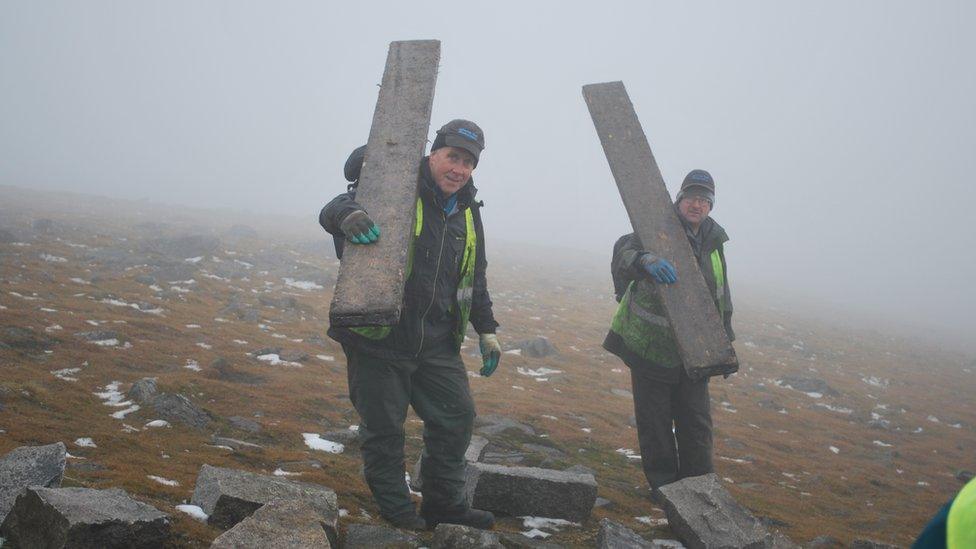 Andrew Rooney and Martin Stevenson carrying scaffolding planks down from the summit of Slieve Donard