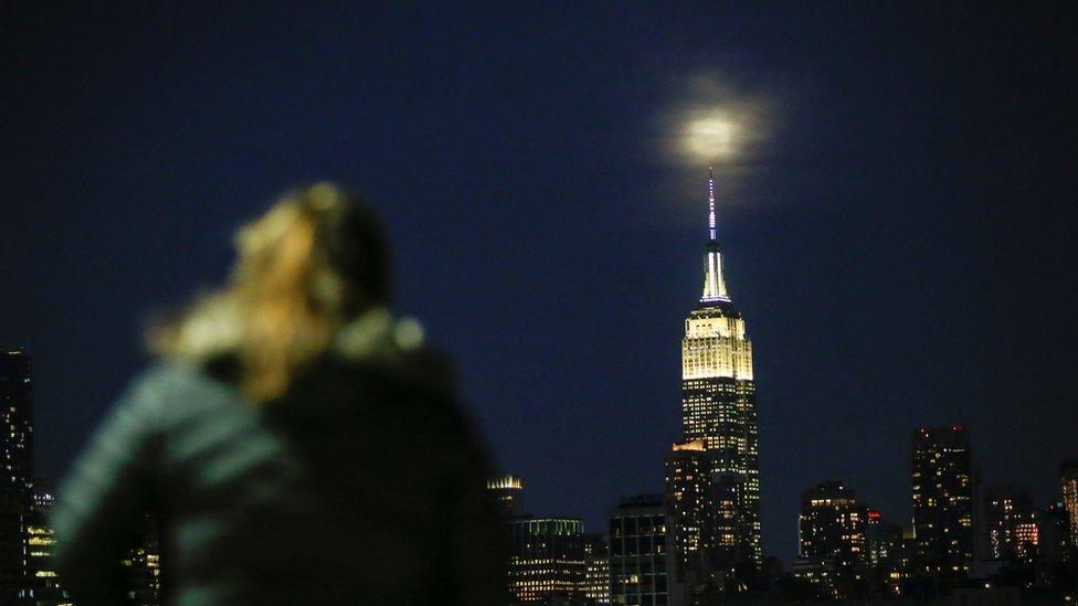 A woman looks at the supermoon in New York