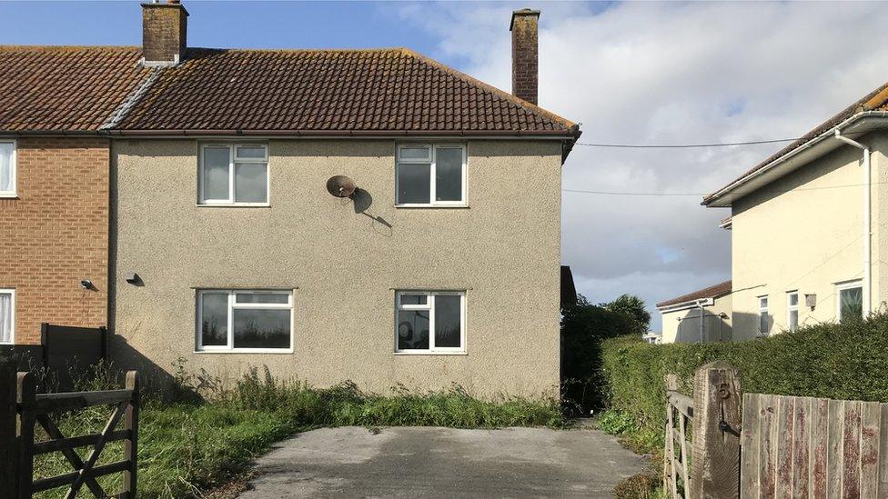 An exterior view of a small brown house