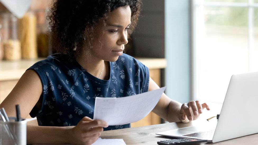 A woman looks at her bills