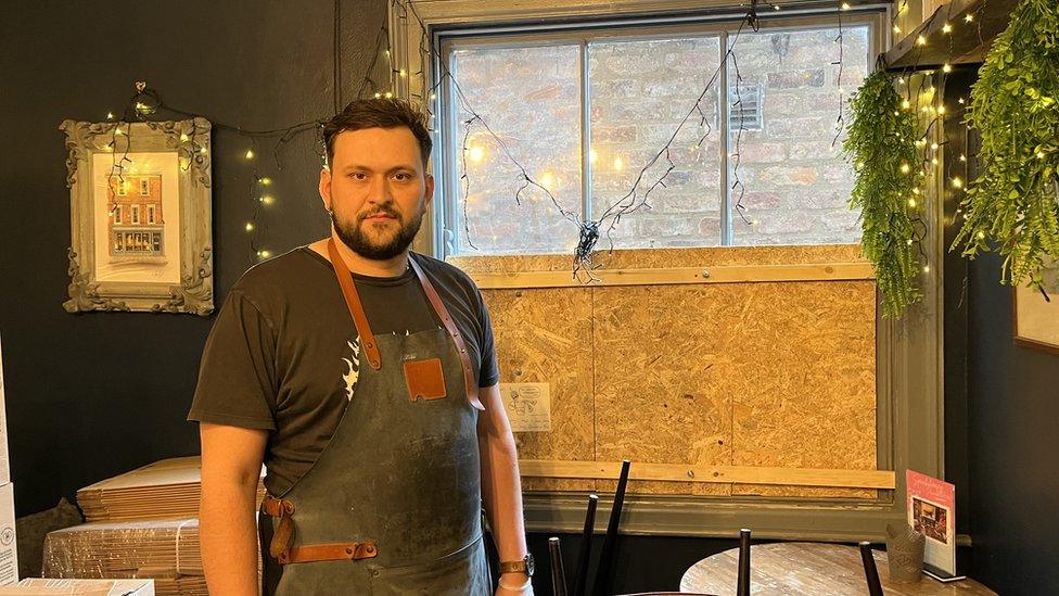 Man stood in front of damaged window