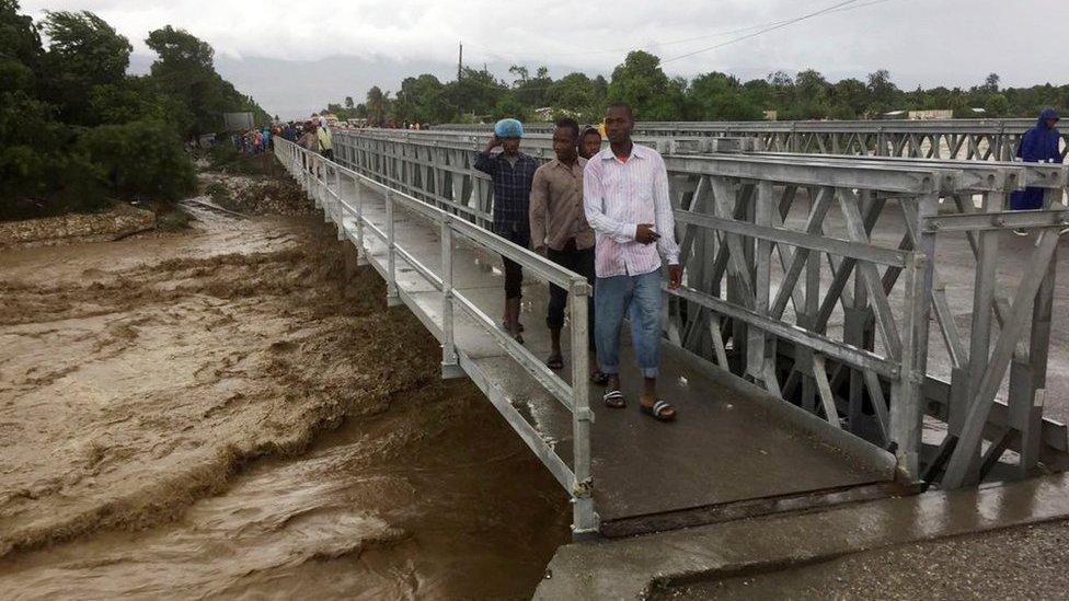 People cross a bridge while Hurricane Matthew passes in Port-au-Prince, Haiti, on October 4, 2016.