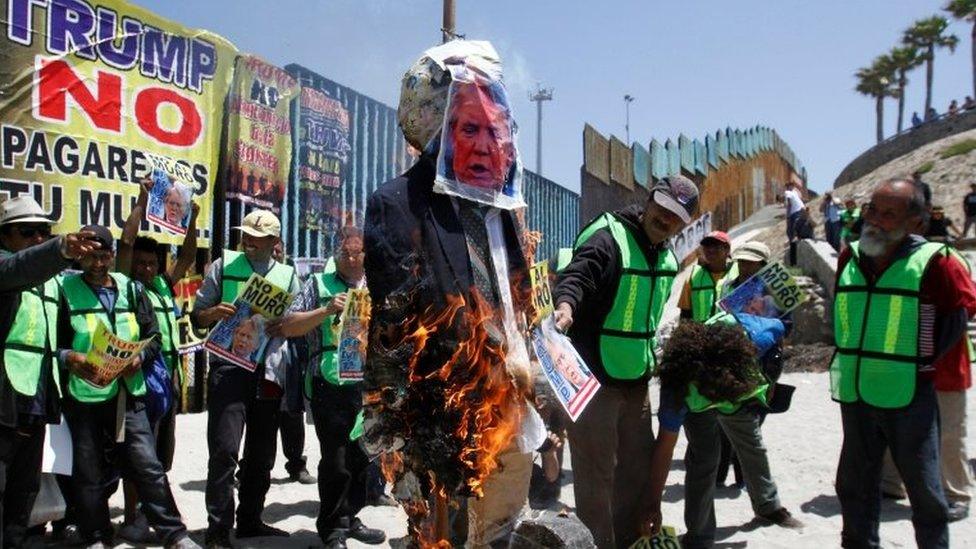 Demonstrators burn an effigy depicting U.S. President Donald Trump during a protest against the immigration policies of Trump"s government near the border fence between Mexico and the U.S., in Tijuana, Mexico May 10, 2018