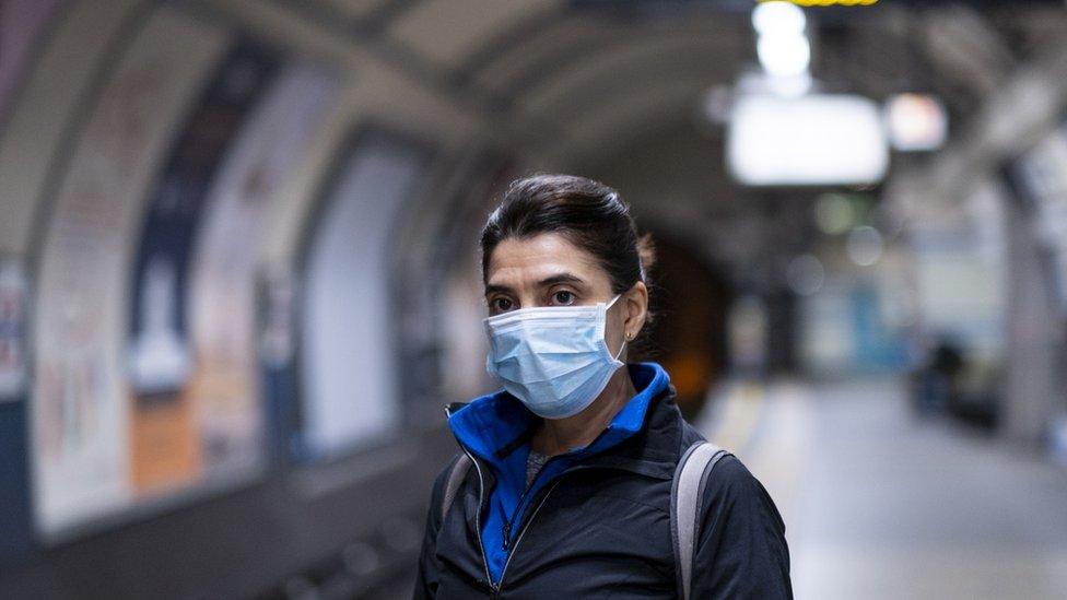 person with mask in tube station