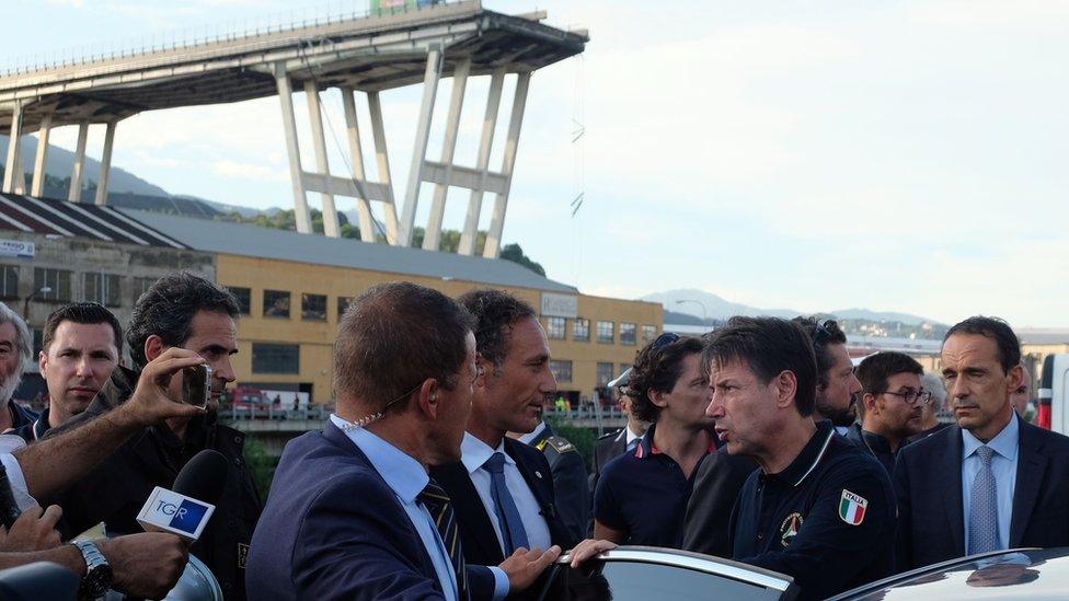 Italian Prime Minister Giuseppe Conte (4th from R) visits the site after a section of the Morandi motorway bridge collapsed in Genoa on August 14, 2018