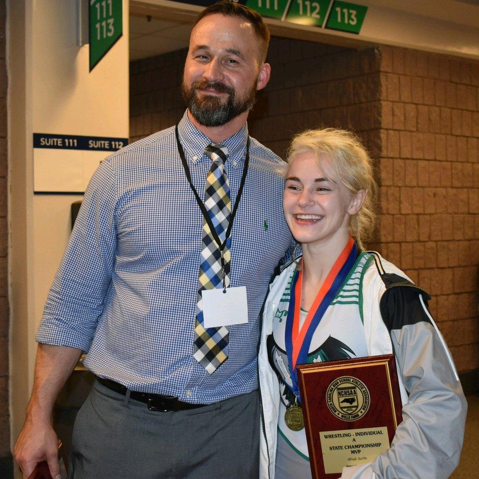 Heaven standing beside a tall man. She is wearing a medal and holding a plaque which reads: "State Championship MVP"