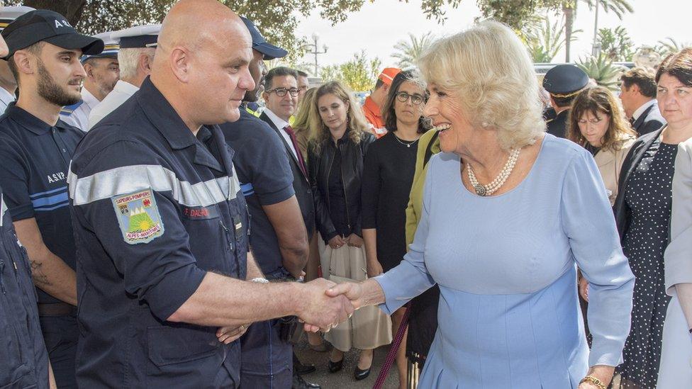 Camilla shakes hands with man in uniform