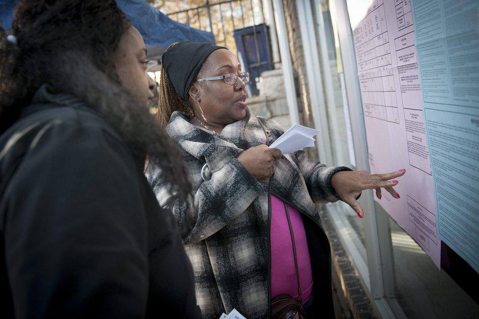 A volunteer talks about ballot measures with a voter outside a polling location for the 2016 US presidential election after polls opened at Wright's Barber Shop in Philadelphia, Pennsylvania, 8 November