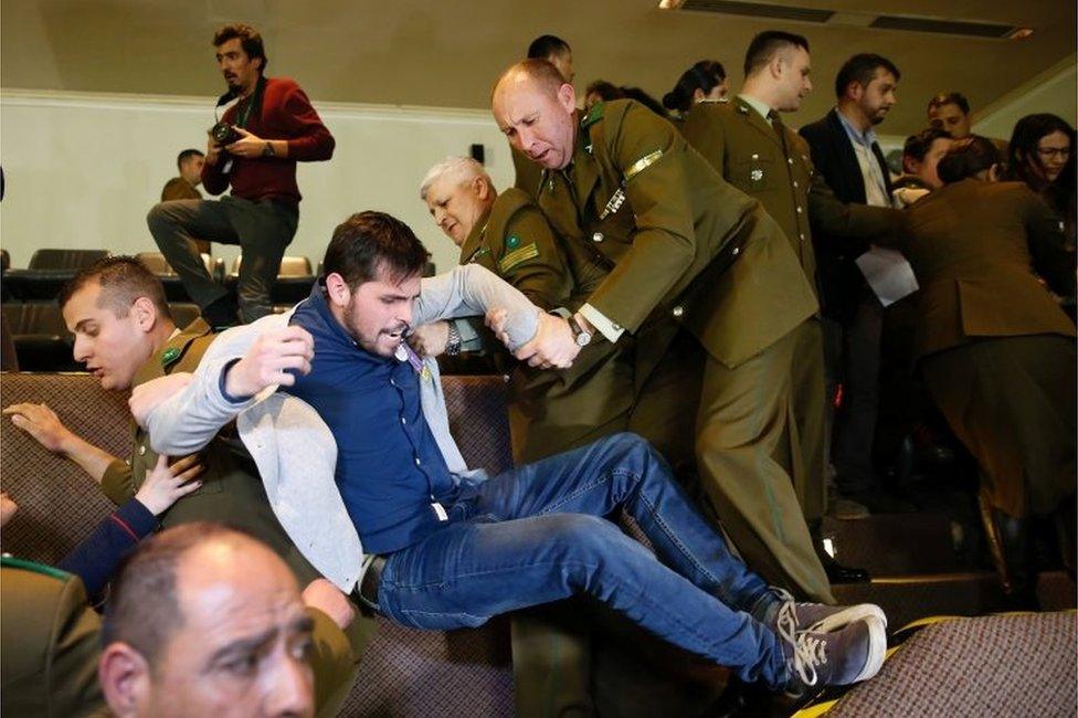 A demonstrator is detained by police officers after shouting slogans against abortion inside the Chilean congress during a session legislating a draft law which seeks to ease the country's strict abortion ban, in Valparaiso, Chile July 18, 2017