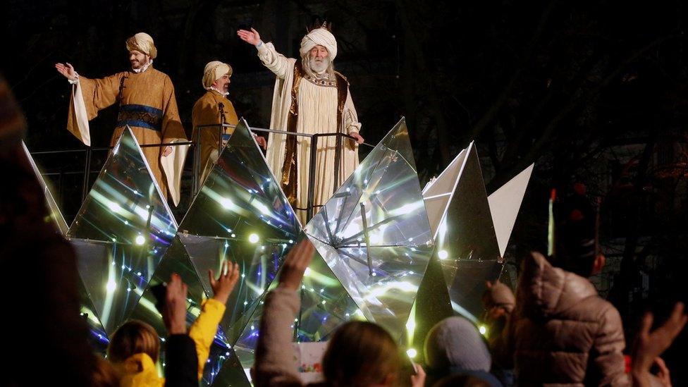 Men dressed as Three Wise Men wave to crowds gathered in Madrid in Spain to celebrate the feast of Epiphany