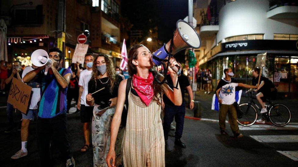 Protesters speak through megaphones during a demonstration against Israeli Prime Minister Benjamin Netanyahu's alleged corruption and his handling of the coronavirus disease (Covid-19) crisis, in Tel Aviv, Israel October 22, 2020