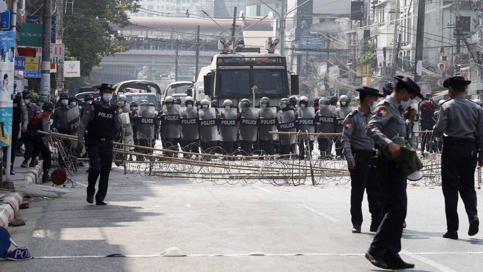 Riot police block a road in Yangon