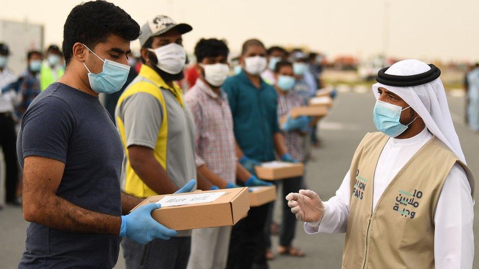 A volunteer distributes iftar meals to migrant workers in Dubai (28 April 2020)