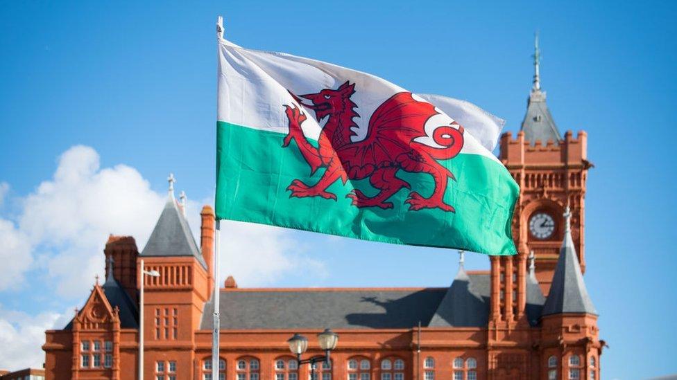 Baner y Ddraig Goch o flaen adeilad y Pierhead ym Mae Caerdydd