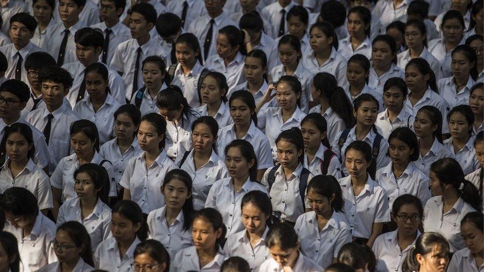 Students take part in a condolence book signing event after the death of the Thai king