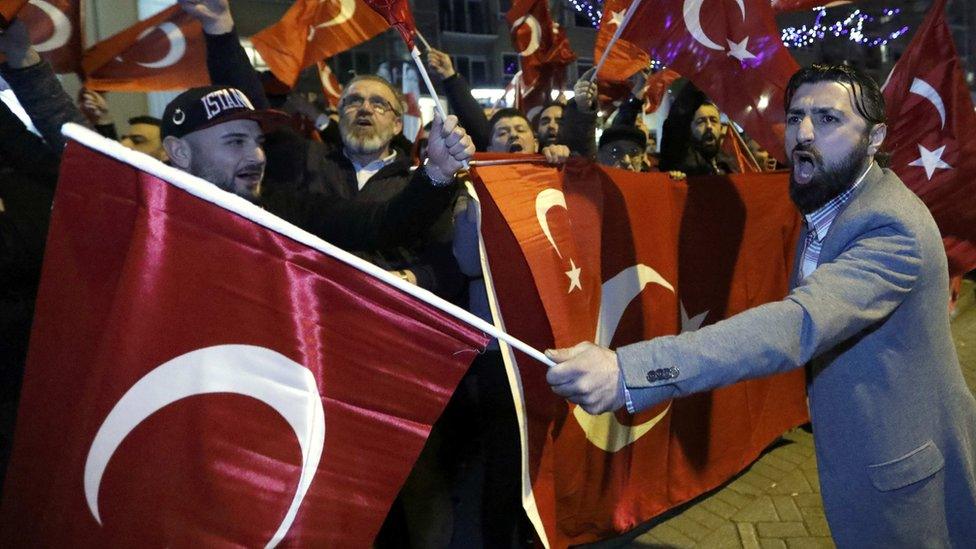 Demonstrators wave flags outside the Turkish consulate in Rotterdam, Netherlands, 11 March 2017