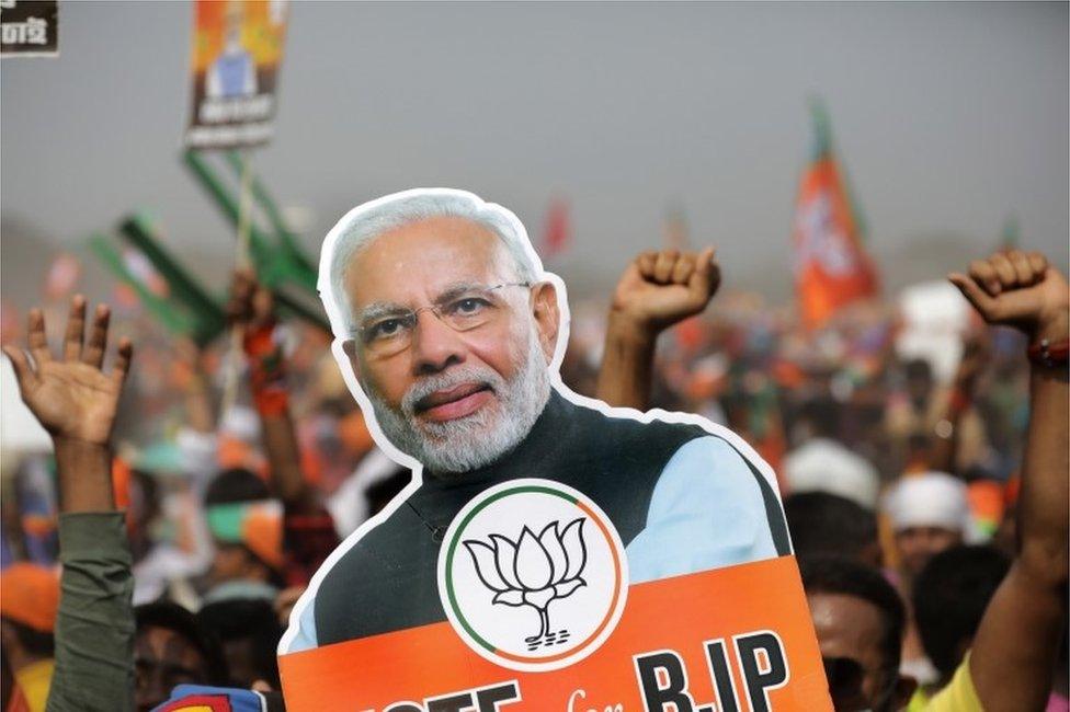 Bharatiya Janata Party (BJP) supporters hold a picture poster of Prime Minister Narendra Modi during a rally by the Indian prime minister Narendra Modi at Brigade Parade Ground in Kolkata, India, 07 March 2021.