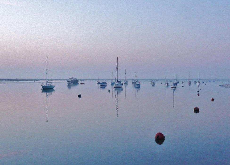 Boats reflected in still water
