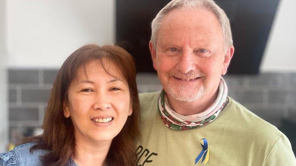 Kev Draper (left) standing close to his his wife Mae both smiling into the camera