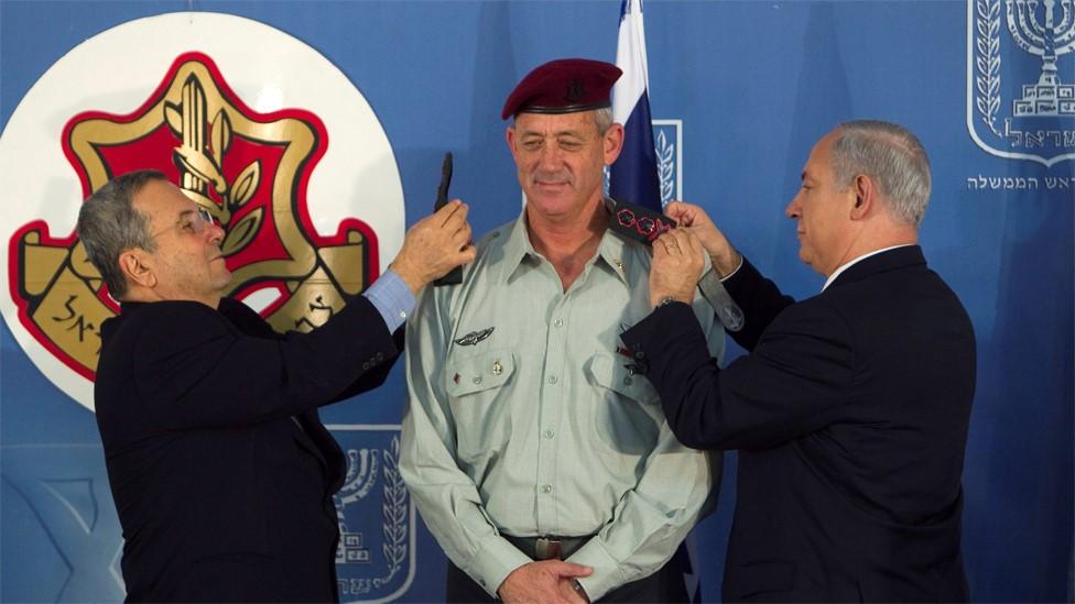 Israeli Defence Minister Ehud Barak (L) and Prime Minister Benjamin Netanyahu (R) change the epaulets of new IDF chief of staff Lt-Gen Benny Gantz (14 February 2011)