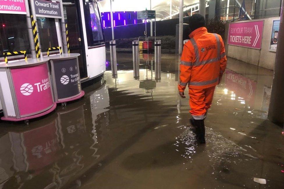 Worker at flooded tram station