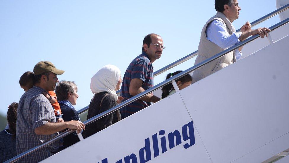 Migants board a plane bound for the Vatican