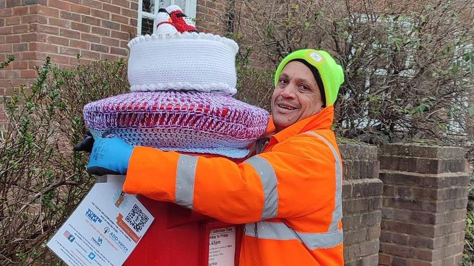 Man putting a post box topper on a post box